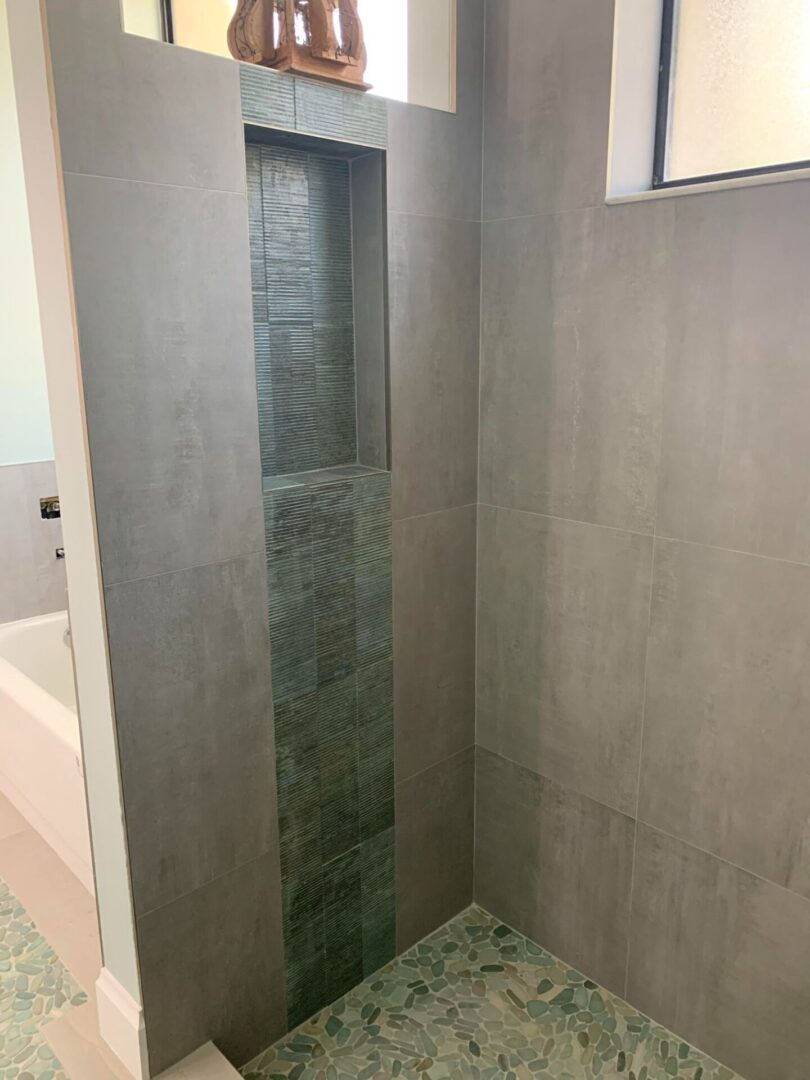 A bathroom with a tiled shower and a tiled floor.