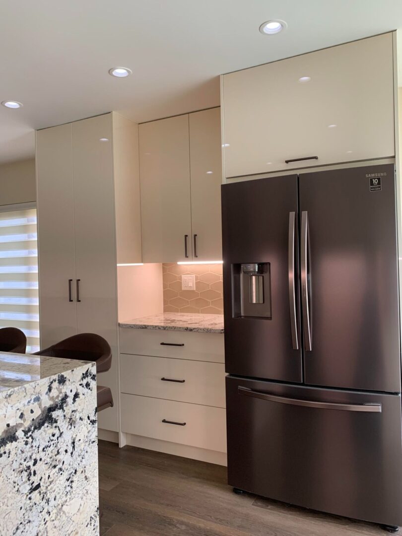 A kitchen with a refrigerator and a counter.