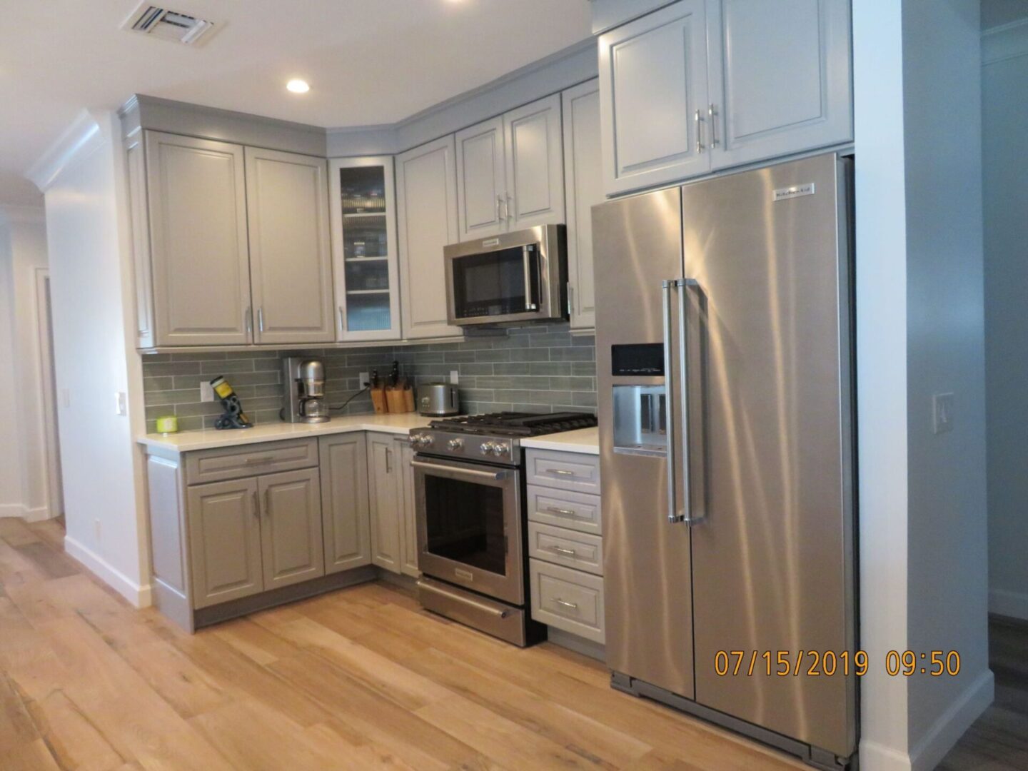 A kitchen with a stainless steel refrigerator and stove.